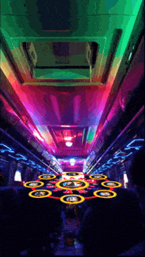 the inside of a bus with a colorful ceiling and circles on the floor