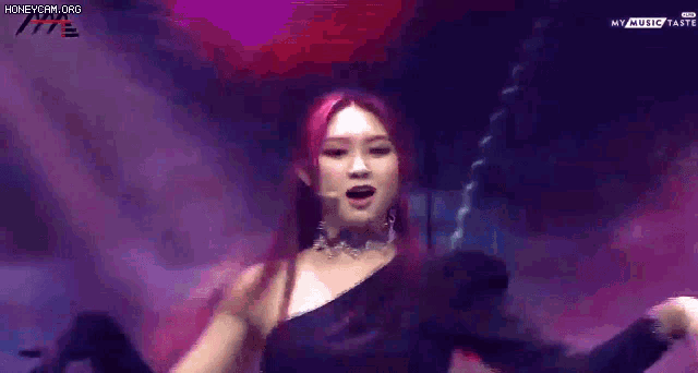 a woman with red hair is singing into a microphone on stage
