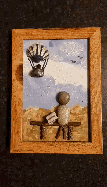 a painting of a person sitting on a bench with a book and a hot air balloon