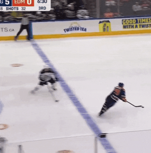 a hockey game is being played with a pizza 7 ad in the background