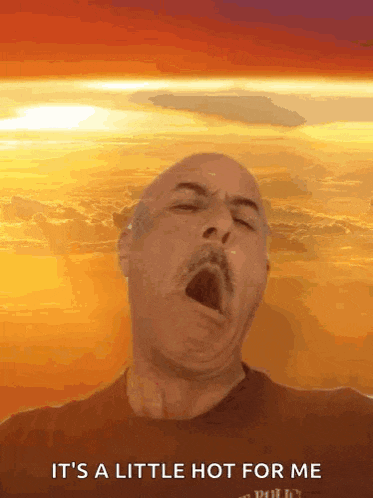 a man is yawning in front of a sunset with the words it 's a little hot for me on the bottom