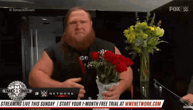 a man with a beard is holding a vase of flowers in front of a fox advertisement