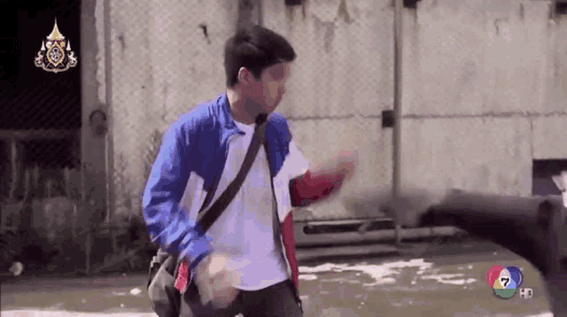 a man in a blue and white jacket is walking down a street