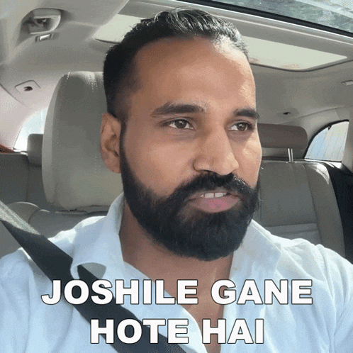 a man with a beard is sitting in the back seat of a car with the words joshile gane hote hai above him