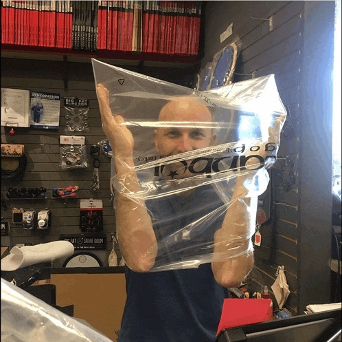 a bald man is holding a plastic bag with the word ibanez on it