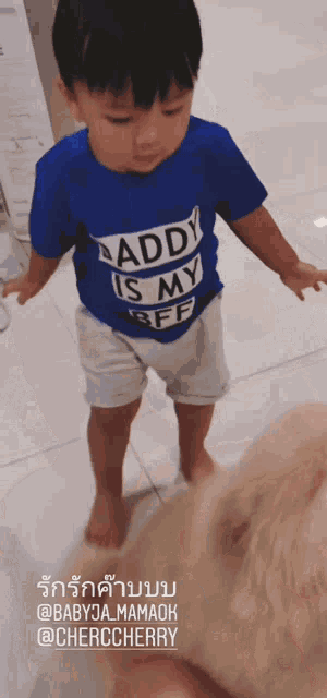 a child wearing a blue shirt that says daddy is my bff
