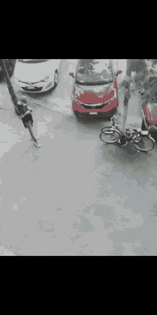 a blurry picture of a street with a red car in the middle