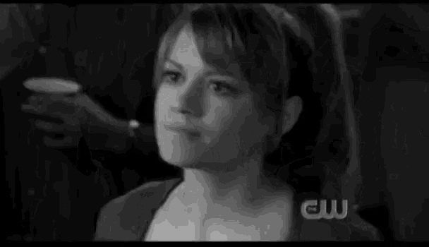 a black and white photo of a woman 's face with a cw logo in the background .