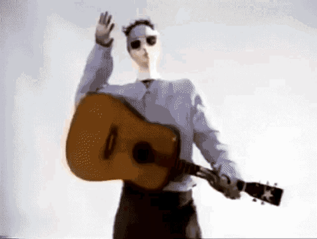 a man with a mask on his face is holding a guitar