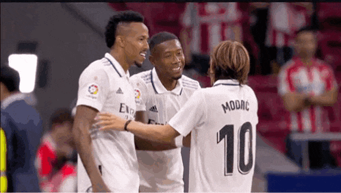 a group of soccer players are hugging and one of them has the number 10 on his back .