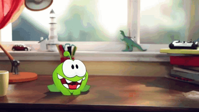 a cartoon character sits on a desk next to a window