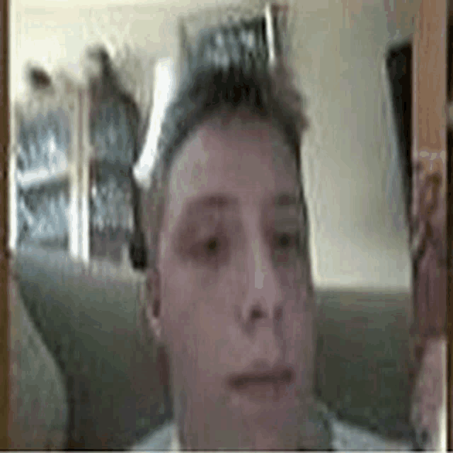 a man is sitting on a couch in front of a mirror and looking at himself .