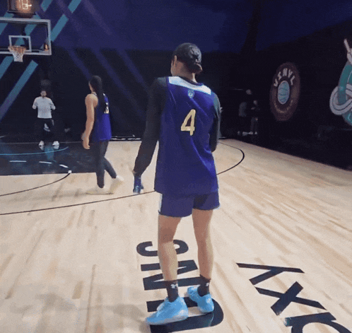 a basketball player wearing a number 4 jersey stands on a court