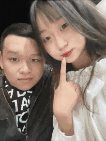 a man and a girl are posing for a picture and the girl is holding her finger to her mouth