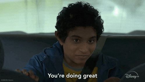a young boy is sitting in the back seat of a car and says you 're doing great
