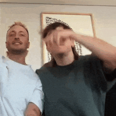 two men are standing next to each other in a room .
