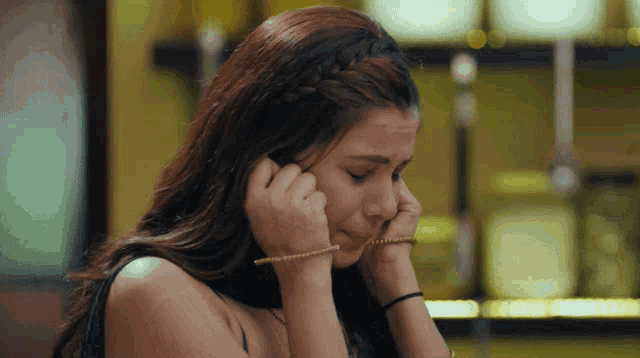 a woman wearing a braided headband is crying