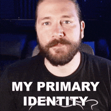 a man with a beard wearing a black shirt that says my primary identity