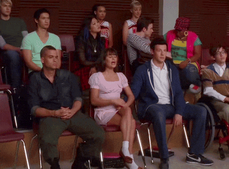 a group of people are sitting in chairs with one wearing a cheerleader uniform that says wmhs