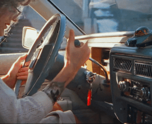 a person is driving a car with a taxi cab on the dashboard