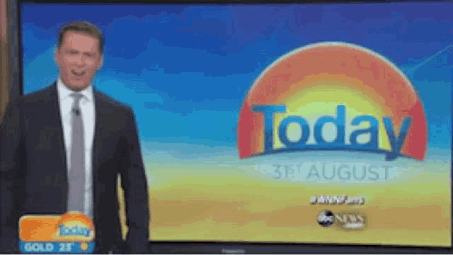 a man in a suit and tie is standing in front of a television screen that says today