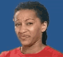 a woman wearing a red shirt is making a funny face .