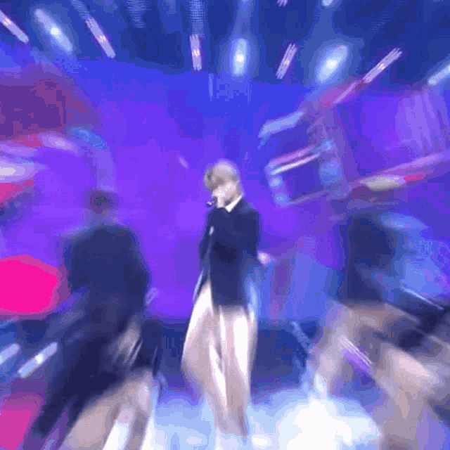 a blurry image of a man singing into a microphone