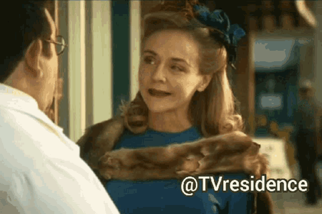 a woman in a blue dress is talking to a man in a white coat with the words @tvresidence written below her