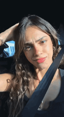 a woman in a car with a seat belt around her neck