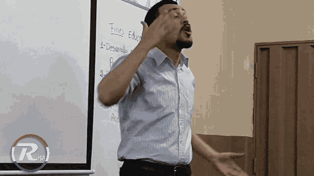 a man stands in front of a whiteboard that says fines educacion
