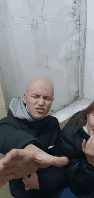 a man with a mask on his face is making a funny face next to a woman