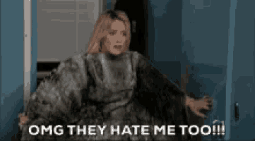a woman in a fur coat is standing in a doorway and says `` omg they hate me too '' .