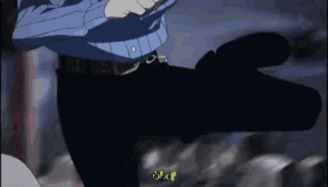 a man in a blue shirt and black pants is standing in the dark holding a gun .