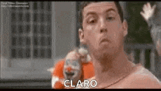 a man without a shirt is standing in front of a clown in a movie .