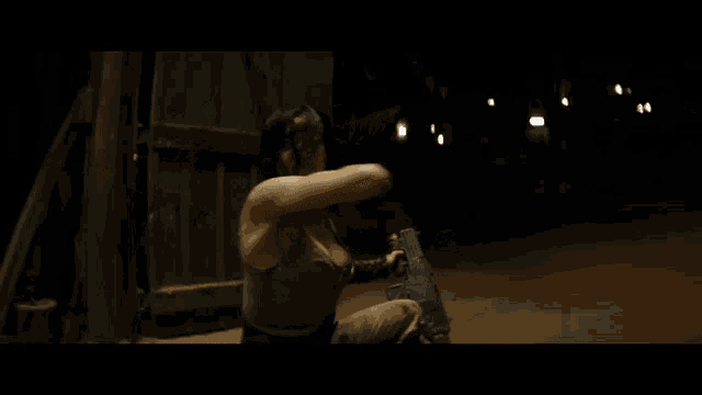 a woman in a tank top is holding a knife in her hand