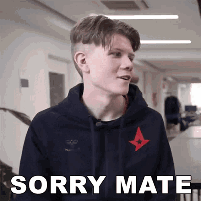 a young man in a hoodie says sorry mate in a hallway