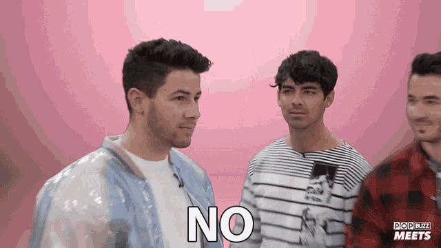 a group of men are standing next to each other and one of them has the word no on his chest