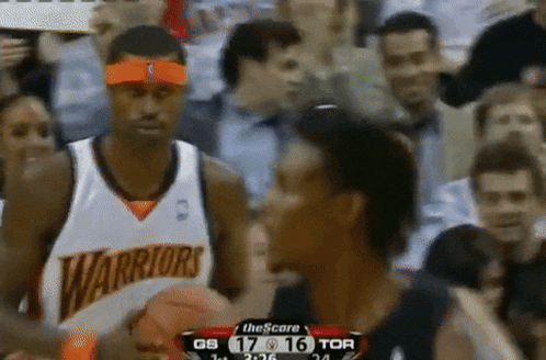 a warriors basketball player holds a basketball in his hand