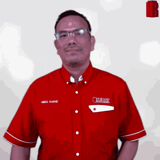 a man wearing a red shirt with the word hebat on the pocket