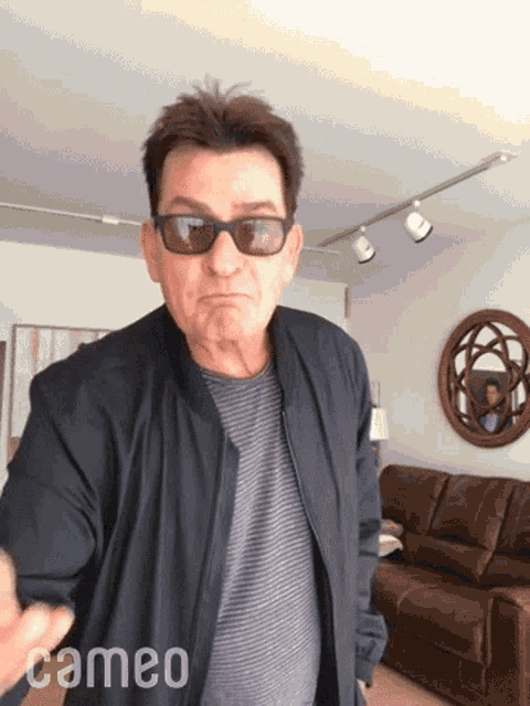 a man wearing sunglasses and a black jacket with cameo written on the bottom right