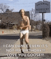 a shirtless man in underwear is running down a street in front of a sign that says entering woonsocket .