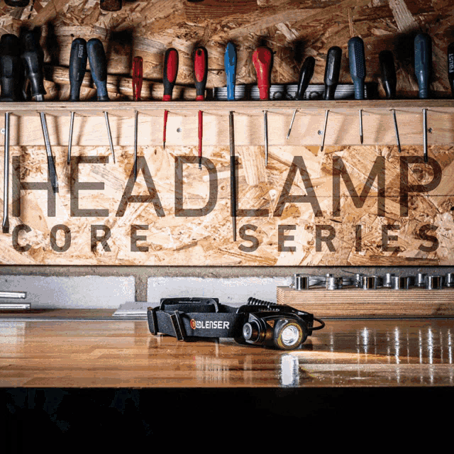 a headlamp is sitting on a wooden table in front of a headlamp core series sign