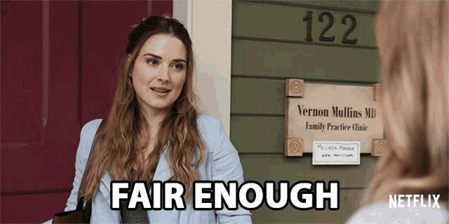 a woman talking to another woman in front of a sign for vernon mullins md