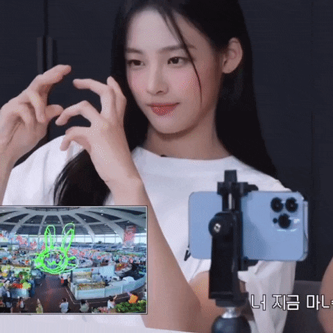 a woman taking a picture with a cell phone and a screen that says gg
