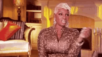 a woman in a gold dress is sitting in a living room with a couch .