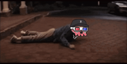 a man wearing 3d glasses is laying on the ground next to a white car
