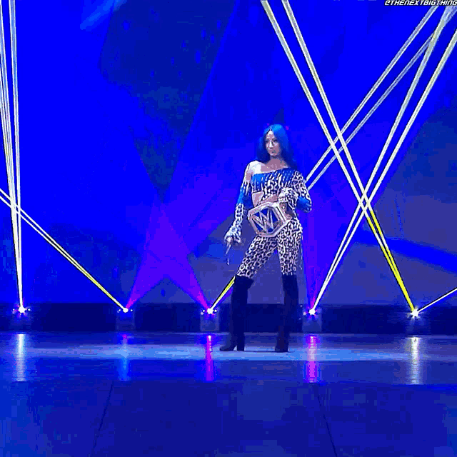 a woman in a leopard print outfit is holding a wwe championship trophy