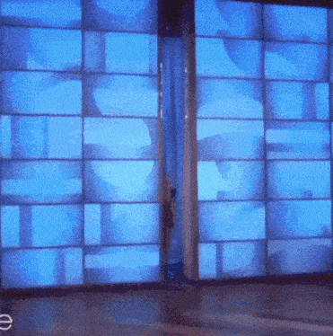 a sliding glass door with a blue light behind it and the letter e in the corner