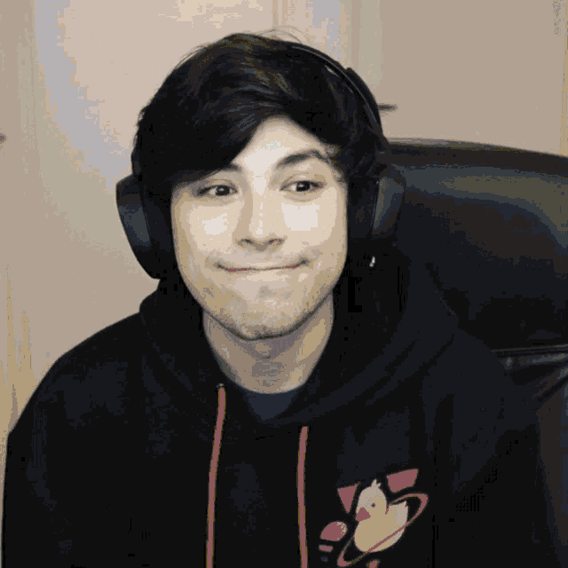 a man wearing headphones and a hoodie with a pink duck on it