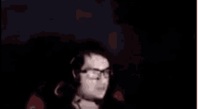 a man with glasses and headphones is giving the middle finger .